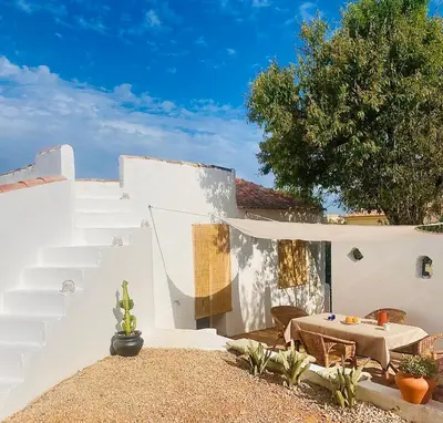 a white house with a table and stairs at Casa Andorinha