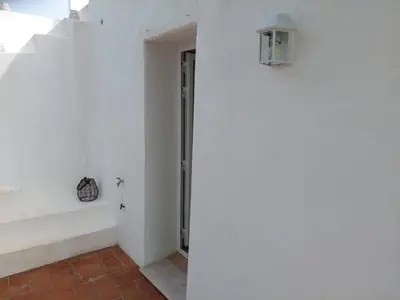 a hallway with a white wall and a stair case at Casa Andorinha