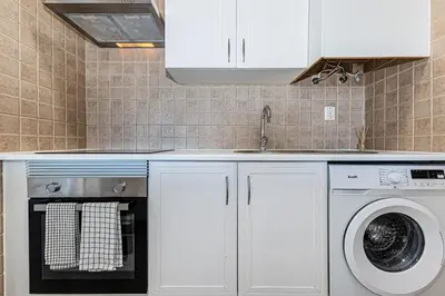 a kitchen with a washing machine and a sink at Le Bleu de la Mer in Albufeira