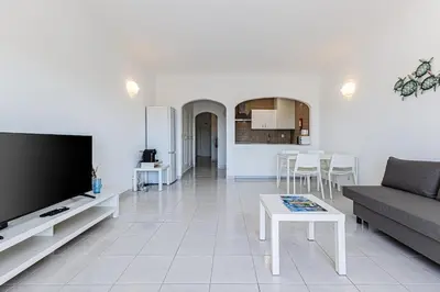 a living room with a couch and a tv and a table at Le Bleu de la Mer in Albufeira