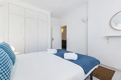 a white bedroom with a blue and white bed at Le Bleu de la Mer in Albufeira
