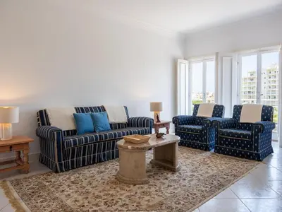 a living room with two couches and a table at Vilamoura Sea View Apartment by Stay ici Algarve Holiday Rental in Quarteira