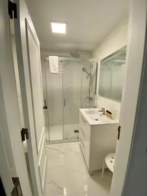 a white bathroom with a shower and a sink at Seaside Inspire Wilderness in Quarteira