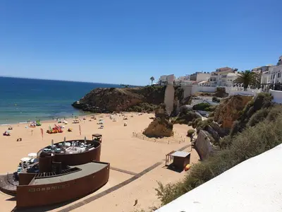 a beach with a bunch of people on the beach at Casa da Porta da Praia - 1 Bedroom Castle Wall Loft in Albufeira