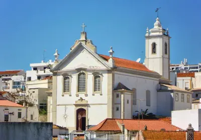 a white church with a tower and a steeple at Casa da Porta da Praia - 1 Bedroom Castle Wall Loft in Albufeira