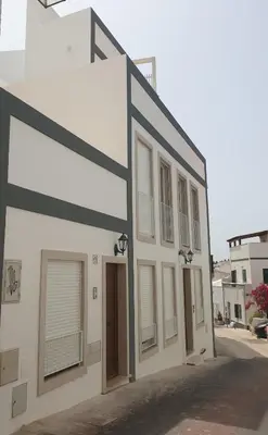 a white building with black trim and windows at Casa da Porta da Praia - 1 Bedroom Castle Wall Loft in Albufeira