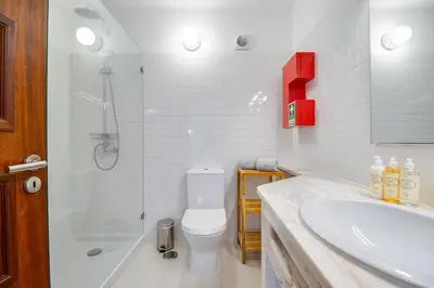 a bathroom with a shower and a toilet and a sink at Relaxing 2BD Apt 500m Beach w AC WiFi Pool in Albufeira
