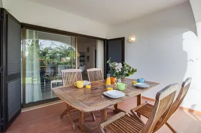 a wooden table and chairs on a patio at Relaxing 2BD Apt 500m Beach w AC WiFi Pool in Albufeira
