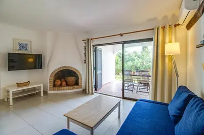 a living room with a blue couch and a fireplace at Relaxing 2BD Apt 500m Beach w AC WiFi Pool in Albufeira