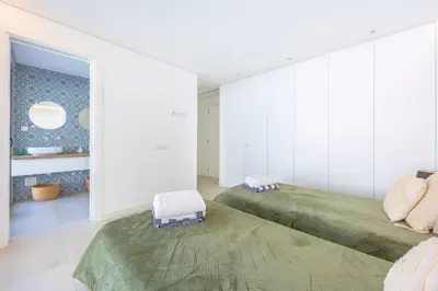 a bedroom with two beds and a green rug at Villa Vista Albufeira Sea Views Heated Pool Walk To Marina in Albufeira
