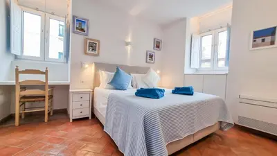 a bedroom with a bed with blue pillows on it at Blue Haven By The Ria - Faro City in Faro