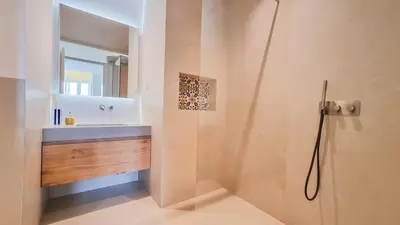 a bathroom with a shower with a sink and a mirror at Blue Haven By The Ria - Faro City in Faro