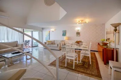a dining room and living room with a table and chairs at Villa Lina - Vilamoura in Quarteira