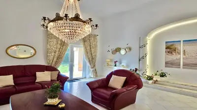 a living room with two chairs and a chandelier at Villa Albatros Cleverdetails, Vilamoura, private pool and jacuzzi in Vilamoura