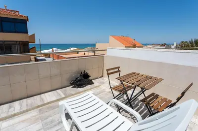 a patio with a table and chairs and the ocean at Blife Charlya private rooms at Faro beach in FAO