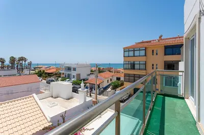 a balcony with a view of the ocean from a building at Blife Charlya private rooms at Faro beach in FAO