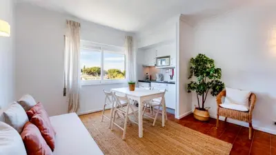 a living room with a table and a kitchen at Studio 54 by Sunnyway in Albufeira