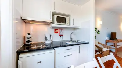 a small kitchen with a sink and a microwave at Studio 54 by Sunnyway in Albufeira