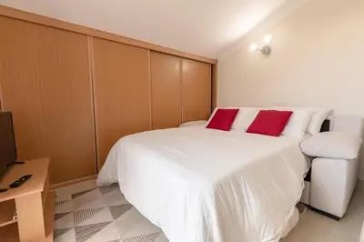a bedroom with a white bed with two red pillows at Rooftop with sea views by Algarve Dream Holidays in Albufeira