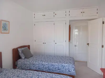 a bedroom with two beds and white cabinets at Vilamoura Pinhal Golf Course in Quarteira