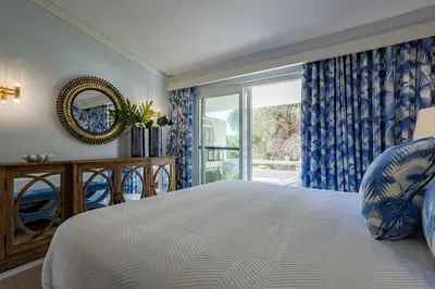 a bedroom with a large bed and a window at The Palm Nest
