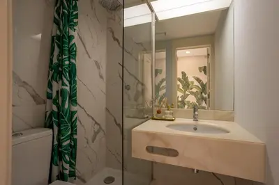 a kitchen with white cabinets and a sink at The Palm Nest