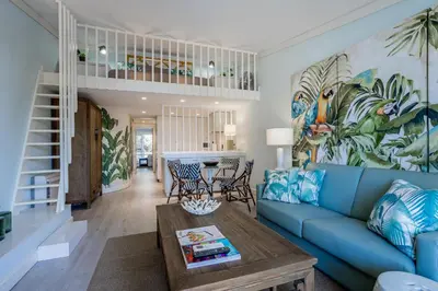a living room with a blue couch and a table at The Palm Nest