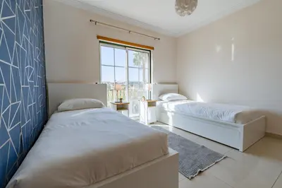 two beds in a bedroom with a blue wall at Condo-Pool walk to the Beach by Algarve Dream Holidays in Albufeira