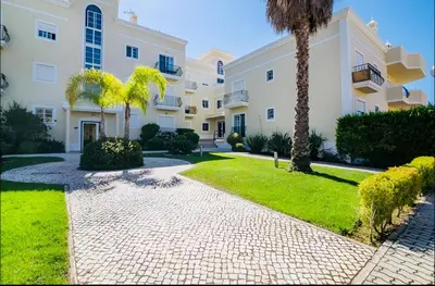 a pathway in front of a building with a palm tree at Condo-Pool walk to the Beach by Algarve Dream Holidays in Albufeira