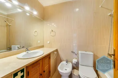 a bathroom with a sink and a toilet and a mirror at Albufeira Breeze Living - Dream Lodging in Albufeira