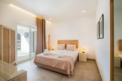a bedroom with a bed and a large window at Casa Joaninha - Heated pool - Algarve in Algoz