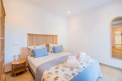 a bedroom with a large bed with blue pillows at Casa Joaninha - Heated pool - Algarve in Algoz