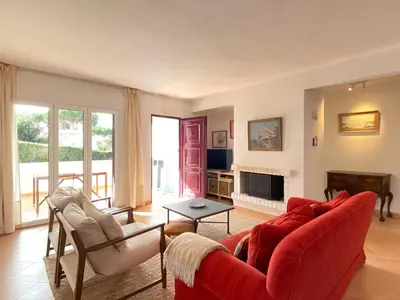 a living room with a red couch and chairs at Casa Manacá Vilamoura in Quarteira