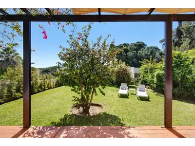 two white chairs and a tree in a yard at Holiday Home Casa Mila - Sunny Way by Interhome in Albufeira