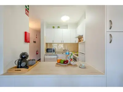 a kitchen with white cabinets and a long hallway at Apartment Ivone - Sunny Way by Interhome in Albufeira