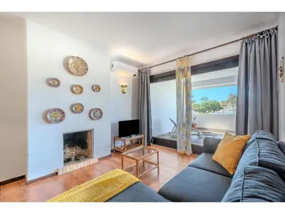 a living room with a blue couch and a fireplace at Apartment Ivone - Sunny Way by Interhome in Albufeira