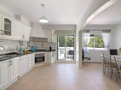 a white bedroom with a large bed and a television at Apartment Kaya- Sunny Way by Interhome in Albufeira