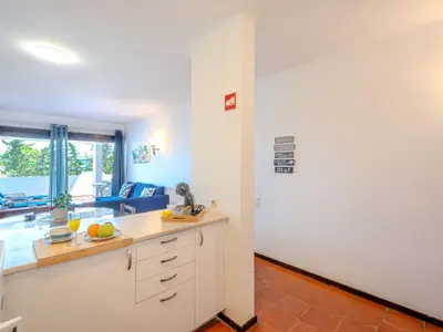a kitchen with white cabinets and a living room at Apartment Lima - Sunny Way by Interhome in Albufeira
