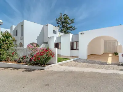 a bedroom with two beds and a table and a desk at Villa Amélia - Sunny Way by Interhome in Albufeira