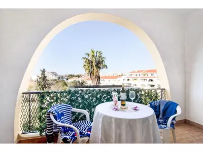 a table with blue and white chairs on a balcony at Apartment Anamar - Sunny Way by Interhome in Albufeira