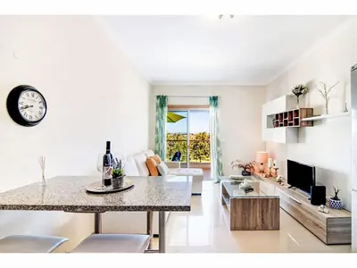 a kitchen and living room with a table and a clock at Apartment Loft 39 - Sunny Way by Interhome in Albufeira