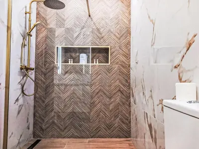 a bathroom with a shower with a tiled wall at Apartment Manelito House - Sunny Way by Interhome in Albufeira