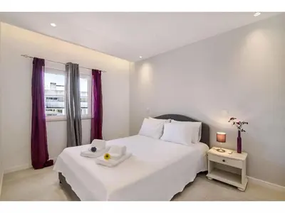 a bedroom with a large white bed and a window at Apartment Max Tropical - Sunny Way by Interhome in Albufeira