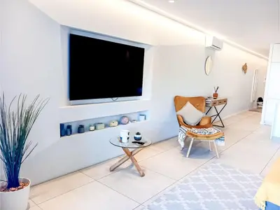 a living room with a tv and a chair at Apartment Sunlight Albufeira - Sunny Way by Interhome in Albufeira