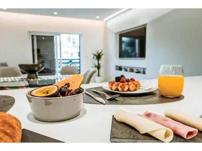a table with a bowl of fruit and a glass of orange juice at Apartment Sunlight Albufeira - Sunny Way by Interhome in Albufeira