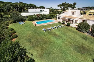 a patio with a table and chairs and a pool at 4 Beds, Golf Views, optional pool heating in Vilamoura