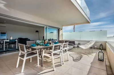 a dining room and living room with a table and chairs at Lovely Modern Apartment With Pool in Albufeira
