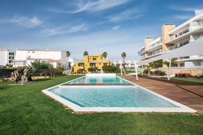 a swimming pool in the yard of a apartment building at Lovely Modern Apartment With Pool in Albufeira