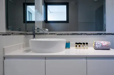 a white bathroom with a sink and a mirror at Vitoria 7th hole by SAPvillas in Vilamoura