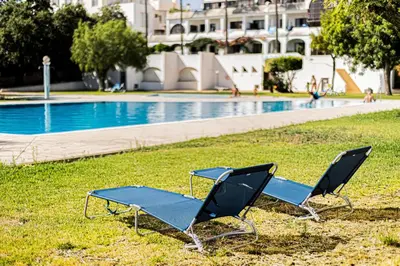 two lounge chairs sitting next to a swimming pool at Ground floor with direct access to swimming pool in Albufeira